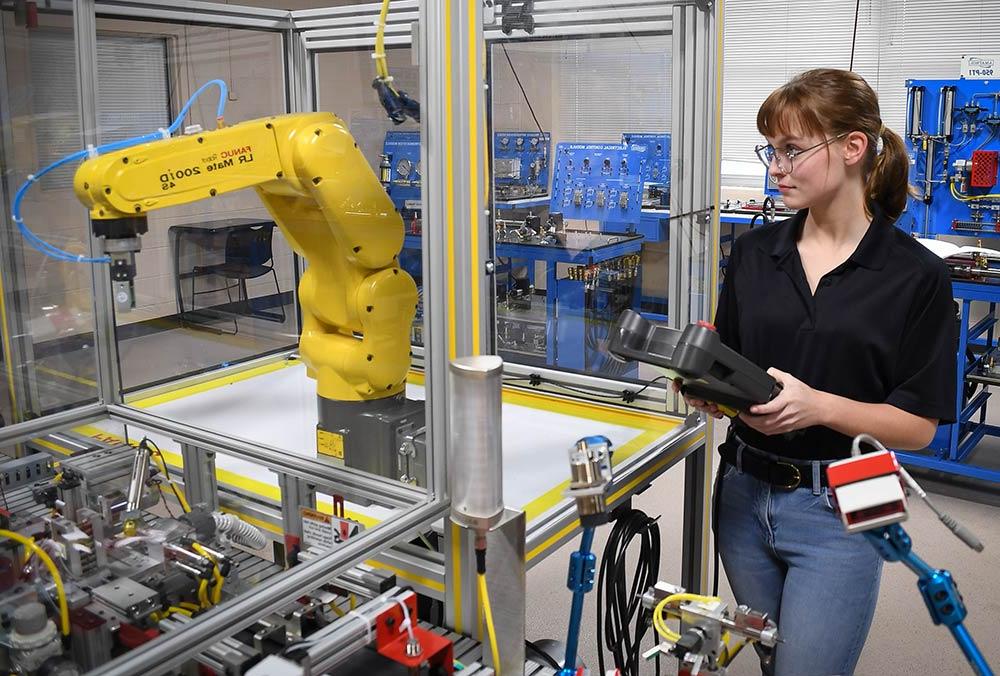 在艾尔斯大学的工业自动化教室里，一名学生正在操作机器人